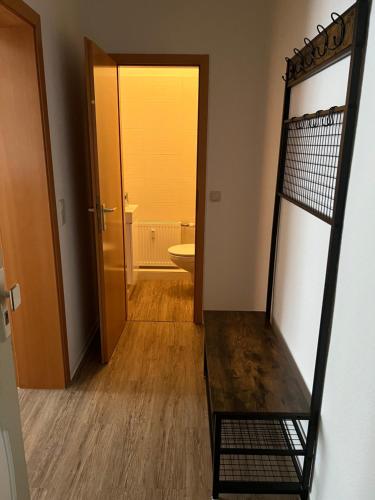a hallway with a bathroom with a toilet and a mirror at Ferienwohnung im Mehrfamilienhaus in Weißwasser