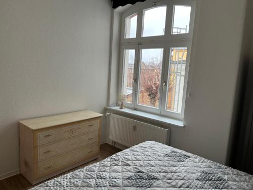 a bedroom with a bed and a window and a dresser at Ferienwohnung im Mehrfamilienhaus in Weißwasser