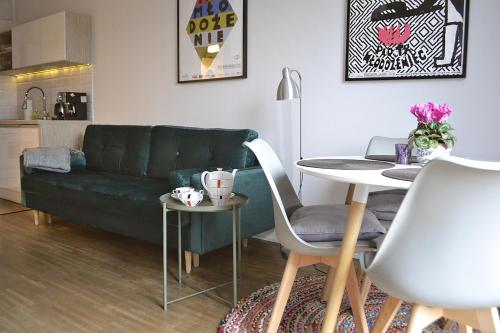 a living room with a green couch and a table at Sopotinn Apartment in Sopot