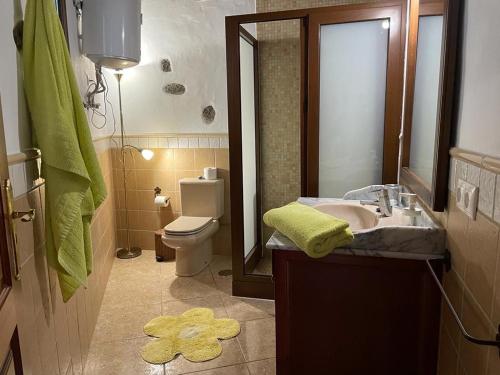ein Badezimmer mit einem Waschbecken, einem WC und einem Spiegel in der Unterkunft Sun, Relax & Lava, Free wifi 600mb, BBQ in Tinajo