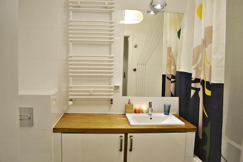 a bathroom with a sink and a mirror at Sopotinn Apartment in Sopot