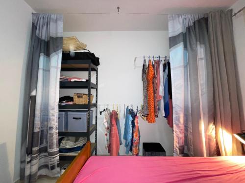 a bedroom with a bed and a closet with clothes at Apartment "Gluecks-Griff" inside "Becici Sunset Apartments" in Budva