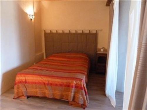 une chambre avec un lit avec une couverture dessus dans l'établissement Charmant loft en campagne, à La Clastre