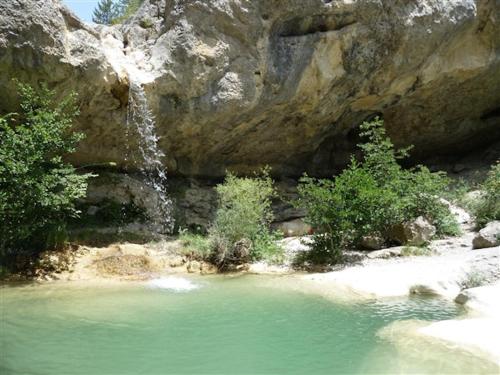 une piscine d'eau en face d'une cascade dans l'établissement Charmant loft en campagne, à La Clastre