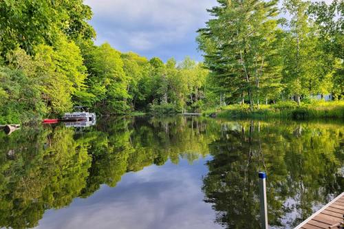 a river with trees and a boat in the water at Wiggin Stream Camp in Greenville