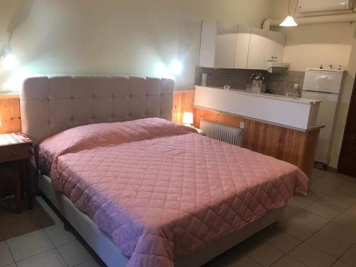 a bedroom with a large bed with a pink blanket at AFISSOS-DREAM 3STUDIOS in Afissos