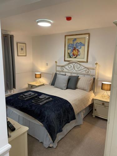 a bedroom with a large bed with two lamps at The Crown Fakenham in Fakenham