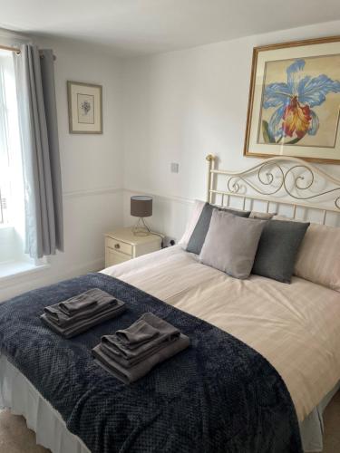 a bedroom with a bed with two towels on it at The Crown Fakenham in Fakenham