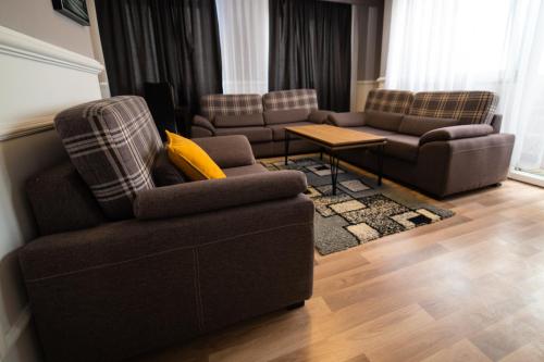 a living room with two couches and a table at CedarTREE Prishtina in Prishtinë