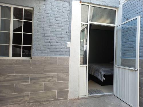 a door leading into a room with a bed in it at Apartamento a minutos caminando del Aeropuerto CDMX Terminal 1 in Mexico City