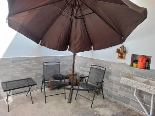 a table and two chairs under an umbrella at Apartamento a minutos caminando del Aeropuerto CDMX Terminal 1 in Mexico City