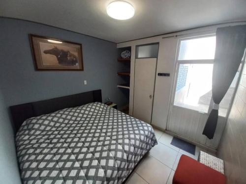 a small bedroom with a bed and a window at Apartamento a minutos caminando del Aeropuerto CDMX Terminal 1 in Mexico City