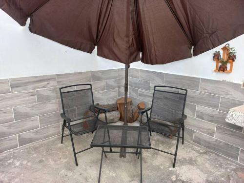 two chairs and a table with an umbrella at Apartamento a minutos caminando del Aeropuerto CDMX Terminal 1 in Mexico City