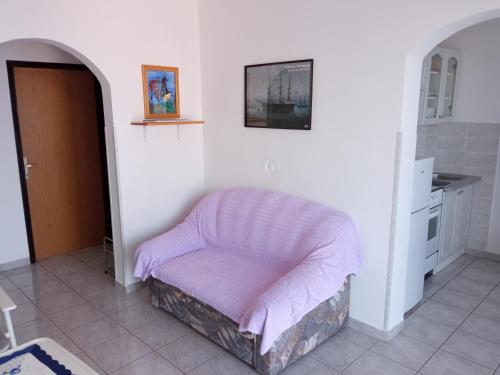 a pink ottoman sitting in a corner of a room at Apartmani Hotko in Sveti Juraj