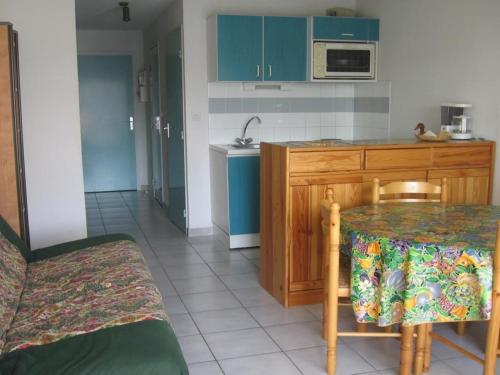 une cuisine avec des placards bleus, une table et un comptoir dans l'établissement T2 27m² avec loggia ouverte, parking privatif à Sète - FR-1-472-107, à Sète