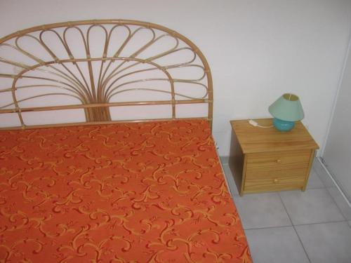 une chambre avec un lit et une table de chevet en bois dans l'établissement T2 27m² avec loggia ouverte, parking privatif à Sète - FR-1-472-107, à Sète