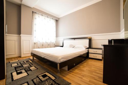 a bedroom with a bed and a window at CedarTREE Prishtina in Prishtinë
