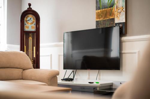 a living room with a large flat screen tv at CedarTREE Prishtina in Prishtinë