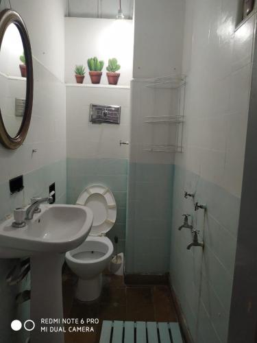 a bathroom with a toilet and a sink and a mirror at Bed & Breakfast Pleno Centro EN CASA PARTICULAR in San Luis