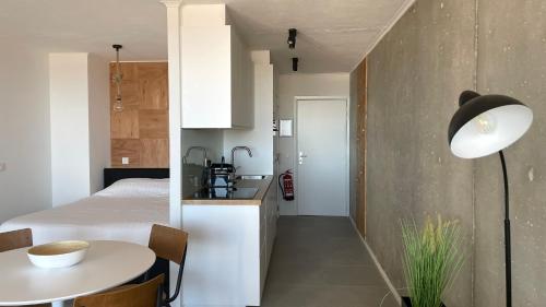 a room with a bed and a table and a kitchen at Sea Shelter in Ostend