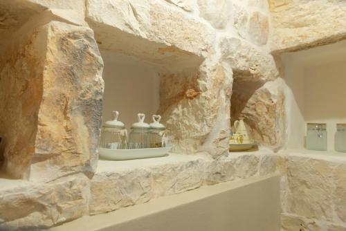 eine Steinmauer mit drei Vasen auf einem Regal in der Unterkunft Il nido delle rondini in Cisternino