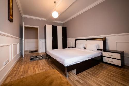 a bedroom with a large bed with white sheets at CedarTREE Prishtina in Prishtinë