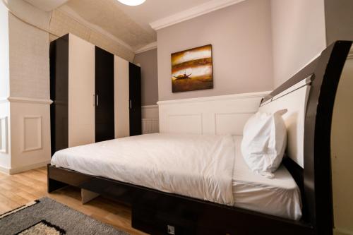 a bedroom with a bed with a black and white headboard at CedarTREE Prishtina in Prishtinë