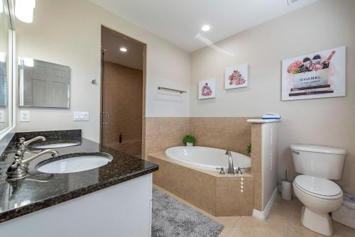 a bathroom with a tub and a toilet and a sink at Vacation home with pool. 4 bedrooms. Sleeps 10 in Naples