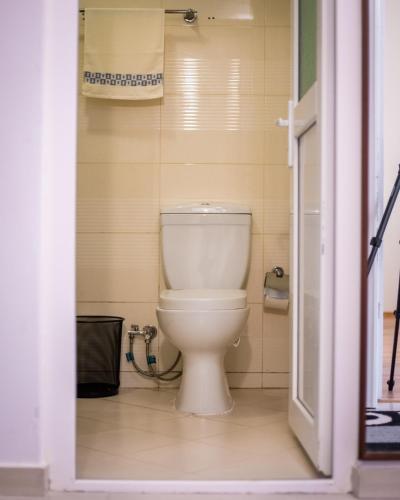 a bathroom with a white toilet in a room at CedarTREE Prishtina in Prishtinë