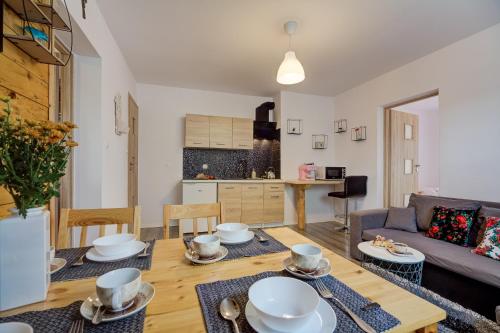 a living room with a table and a couch at Apartamenty Migaczówka in Tylicz