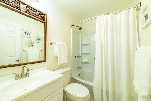 a bathroom with a sink and a toilet and a shower at You can't get closer to the beach than this beachy 3 bedroom condo in Siesta Key