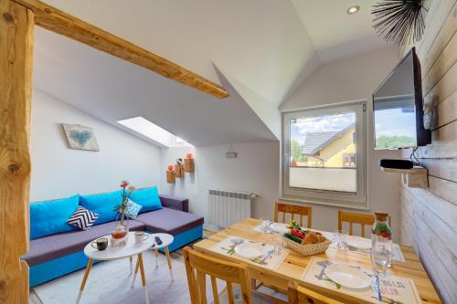 a living room with a blue couch and a table at Apartamenty Migaczówka in Tylicz