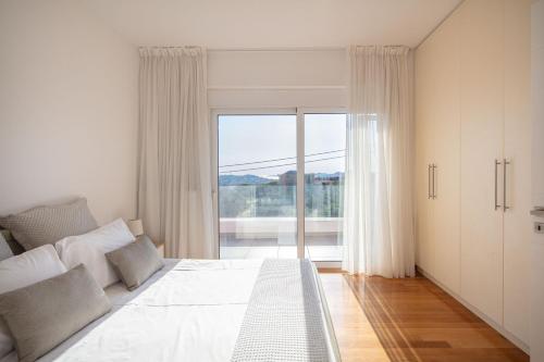 1 dormitorio con cama grande y ventana grande en Grand Panoramic Villa Lagonissi, en Lagonisi