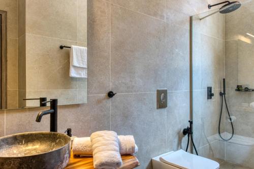 a bathroom with a shower and a sink and a tub at Kavos beach house in Pefki Rhodes