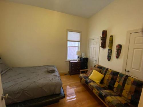 una sala de estar con una cama y un sofá en 2 bedroom Boston condo in Jamaica Plain with parking, en Boston