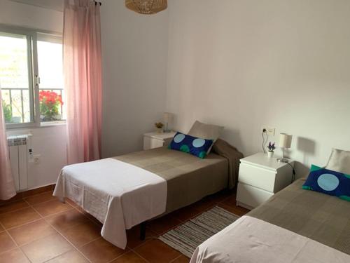 ベレス・ブランコにあるLa Casa de Sally- Vèlez Blancoのベッドルーム1室(ベッド2台、窓付)