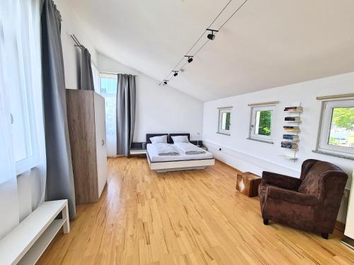 a large living room with a couch and a chair at Apartment am Rohrbach in Friedrichshafen