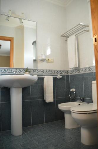 a bathroom with a sink and a toilet and a mirror at Casa de Conde in Coirón