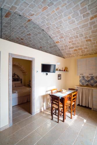 Una cocina y un comedor con mesa y sillas. en Trulli Ad Maiora, en Alberobello