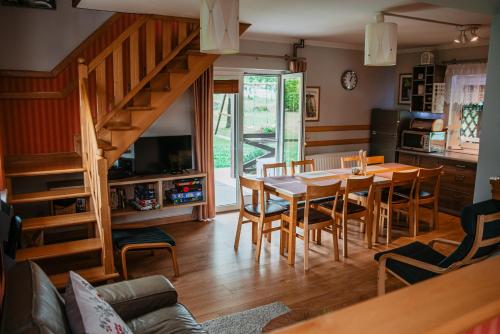 eine Küche und ein Esszimmer mit einem Tisch und Stühlen in der Unterkunft Szmaragdowy domek in Nowy Wiśnicz
