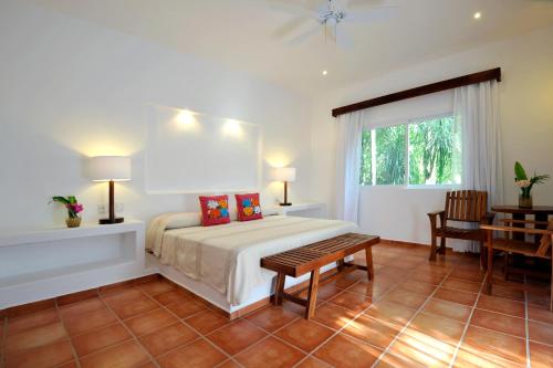 a hotel room with a bed and a table at Hotel Rancho Encantado in Bacalar
