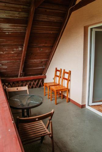 a porch with two chairs and a table and a table and chairs at Szmaragdowy domek in Nowy Wiśnicz