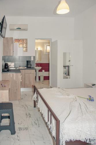 a bedroom with a bed in the middle of a kitchen at Petros Giatras - Rooms in Zakynthos Town