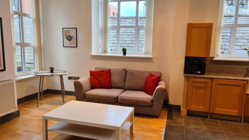 a living room with a couch and a table at Spacious, bright and airy city centre flat. Unique converted Mill. in Manchester