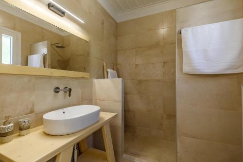 a bathroom with a white sink and a shower at Skopelitian Relaxing House in Skopelos Town