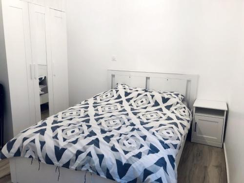 une chambre avec un lit avec une couette bleue et blanche dans l'établissement Appartement moderne & cosy au cœur de Paris, à Paris