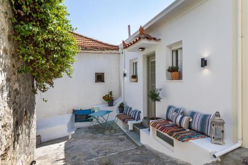 a white house with a bench and a table at Skopelitian Relaxing House in Skopelos Town