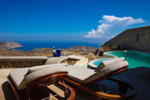 a reclining chair sitting next to a swimming pool at Amallini Suites Mykonos in Super Paradise Beach