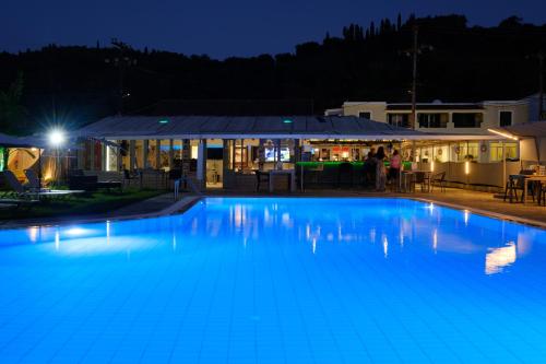 a large swimming pool at night with a restaurant at Katsaros Studios & Apartments in Sidari
