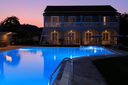 a large swimming pool in front of a house at Katsaros Studios & Apartments in Sidari